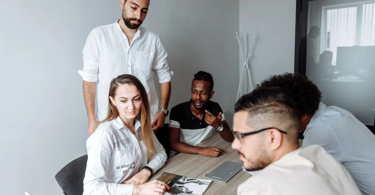Un groupe de collègues divers engagés dans une réunion d'affaires autour d'une table de bureau partagée.
